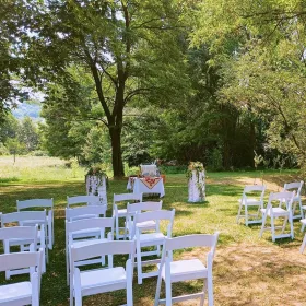 Ceremonie umanistă în aer liber, în Transilvania cu scaune albe și un altar frumos decorat cu flori de grădină