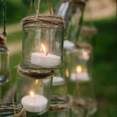 Decor magic pentru o nuntă rustică în aer liber, cu borcănele simple atârnate, folosite pe post de felinare.