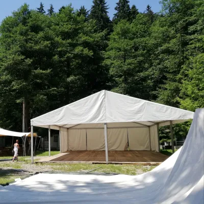 Cort eveniment clasic de închiriat cu bare de aluminiu configurat cu mai multe membrane fixate pe scheletul dat de barele de aluminiu.