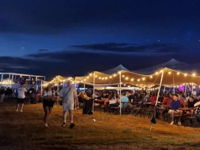 A large tent at the Vibe festival in Transylvania,  night atmosfere with string lights.